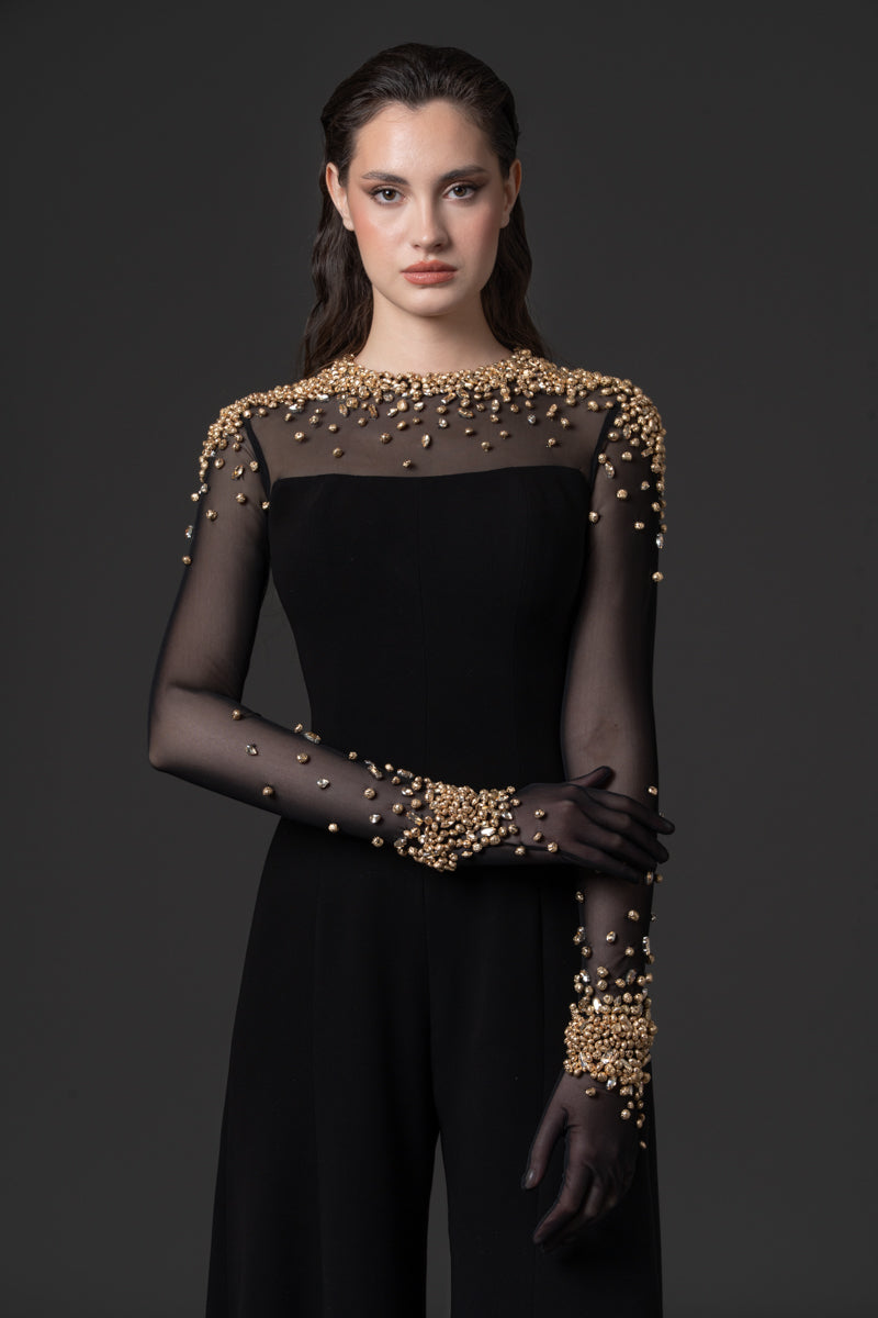 A crêpe jumpsuit with a sheer high neck tulle bodice beaded with metallic stones