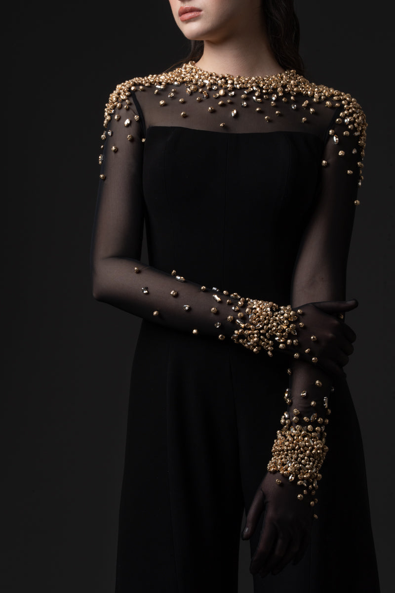 A crêpe jumpsuit with a sheer high neck tulle bodice beaded with metallic stones