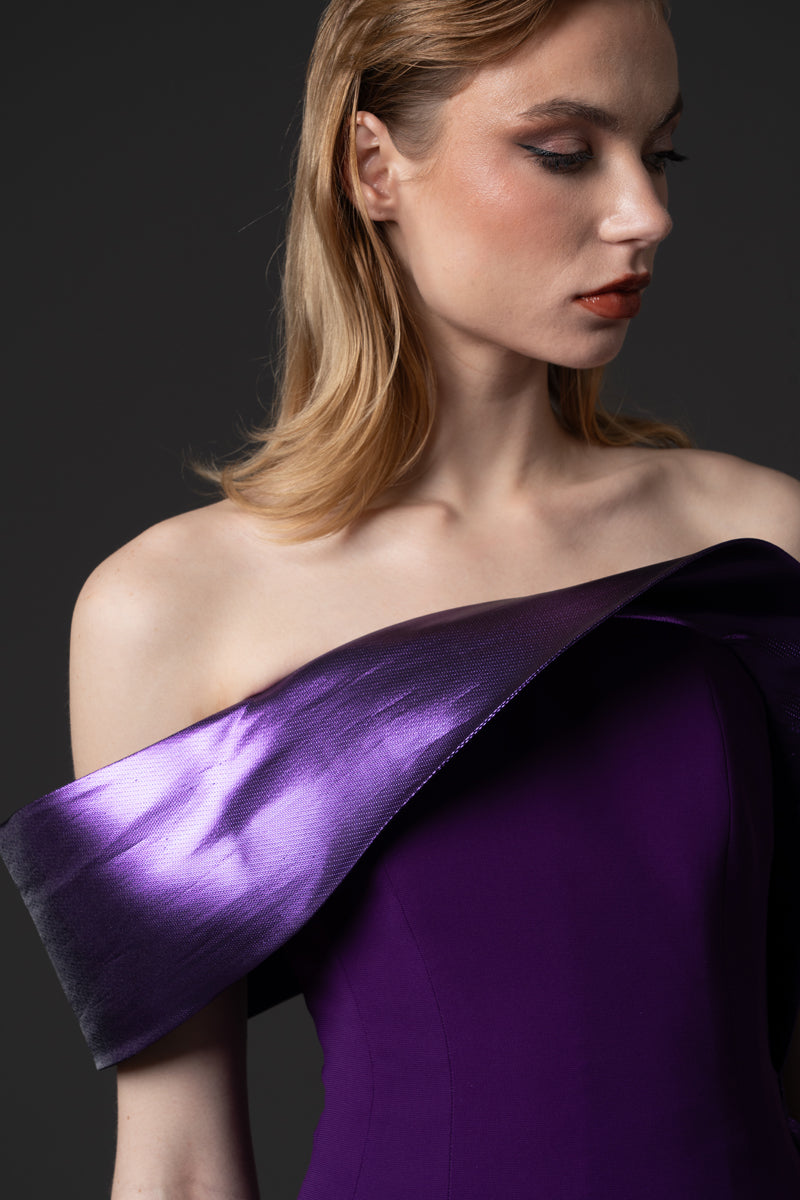 A fitted crêpe gown with a sculptural neckline layered with a  voluminous  asymmetrical lamé overskirt