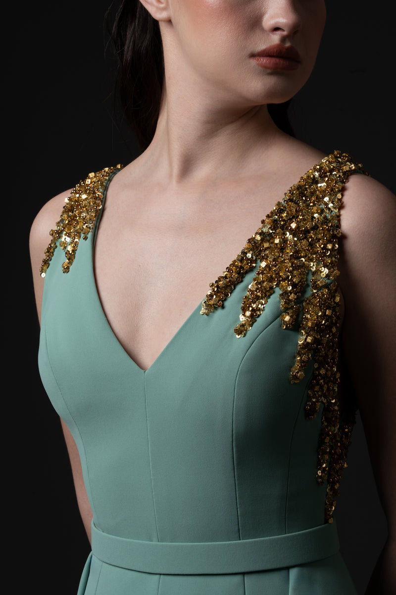 A fitted  crêpe gown with an overskirt and sequins on shoulders