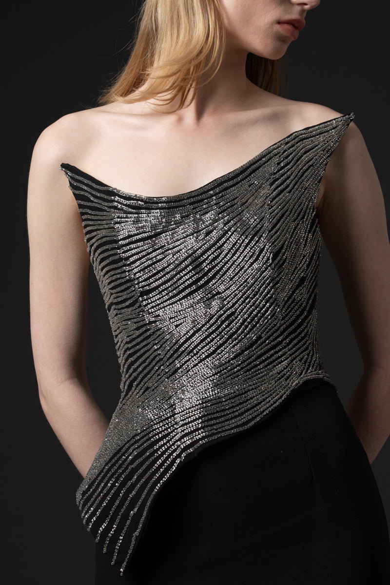 A fitted mermaid crêpe gown designed with a beaded pointed  corset