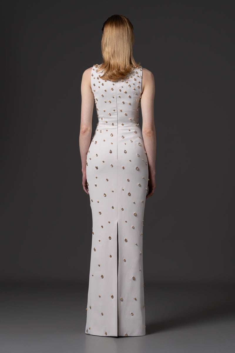 A fitted round neckline crêpe gown beaded with navette stones with a radzimir bomber jacket