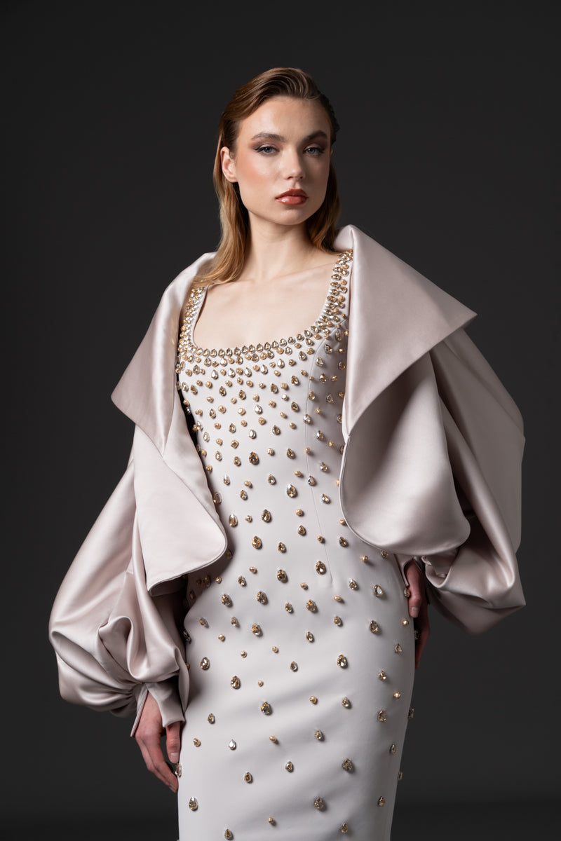 A fitted round neckline crêpe gown beaded with navette stones with a radzimir bomber jacket