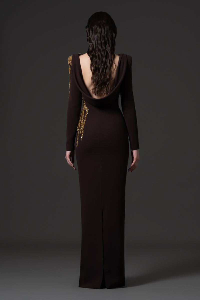 A long sleeves fitted crêpe gown with an open back  and beaded with  sequins