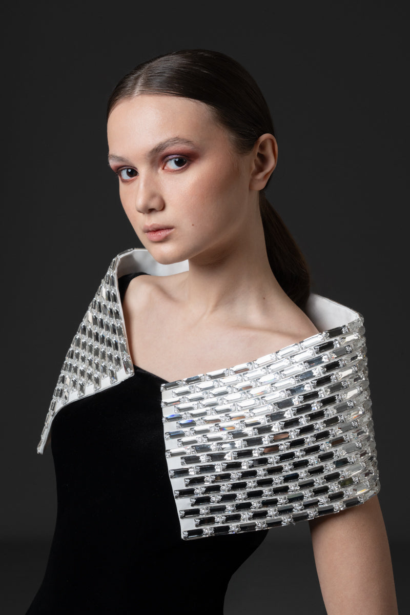 A sculptural velvet gown featuring a baguette-stone encrusted collar that  adds contrast to the look.