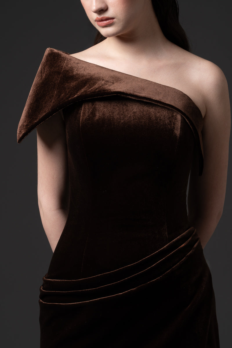 An asymmetrical velvet dress with draping on the waist and a high slit