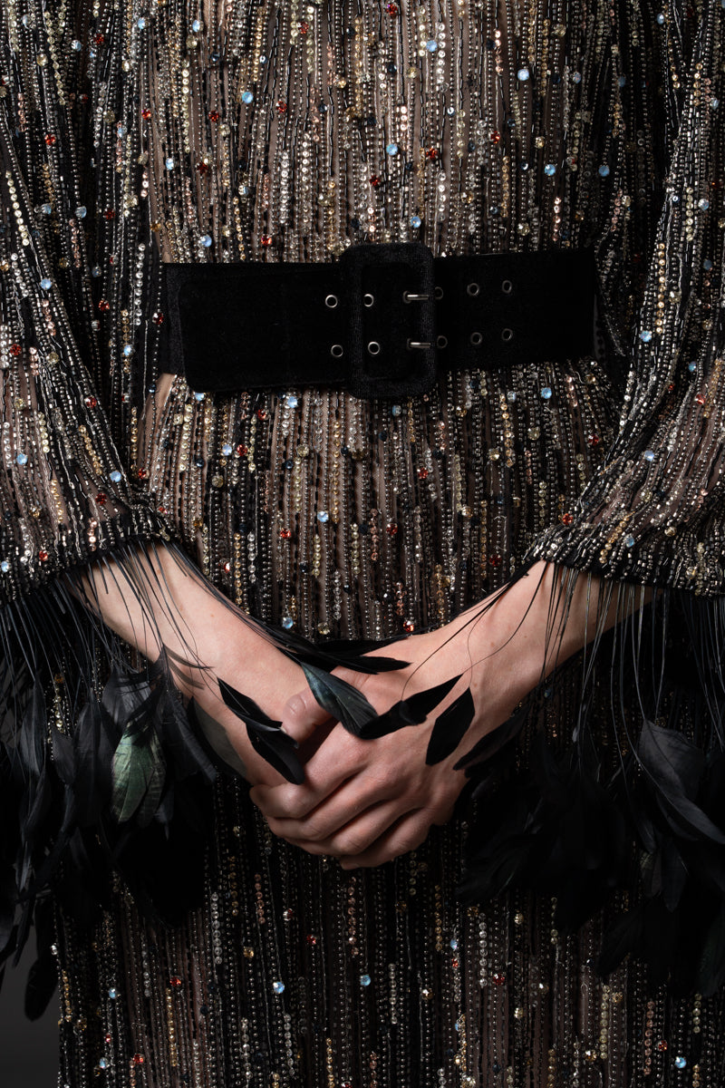 An embroidered kaftan gown with high neck and wide sleeves with feathers