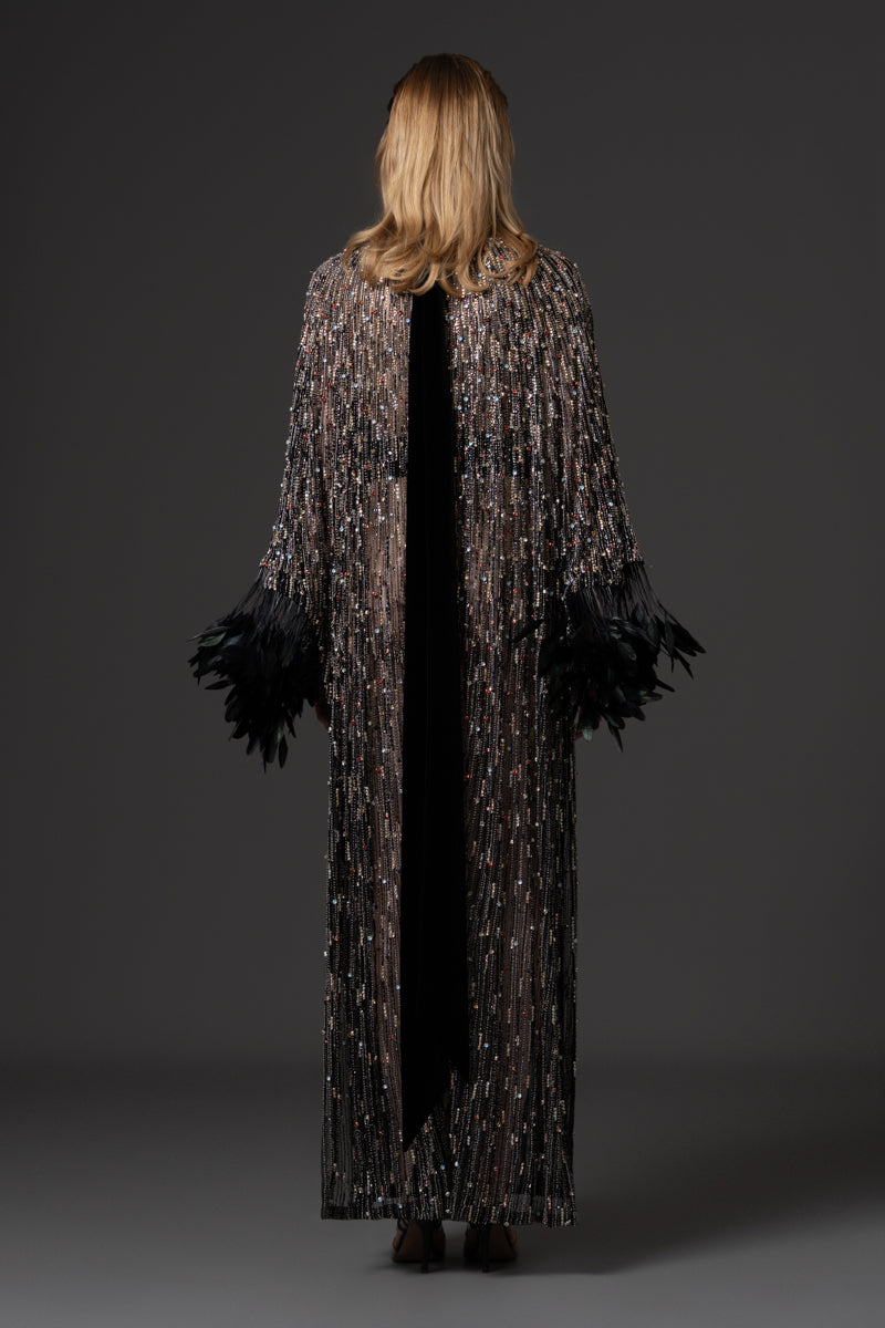 An embroidered kaftan gown with high neck and wide sleeves with feathers