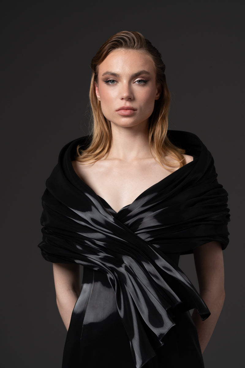 An off-shoulder liquid gazar dress with sculptural draping on the bust