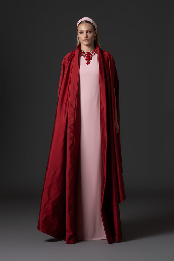 Pink crêpe abaya paired with a red taffeta cape