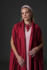 Pink crêpe abaya paired with a red taffeta cape