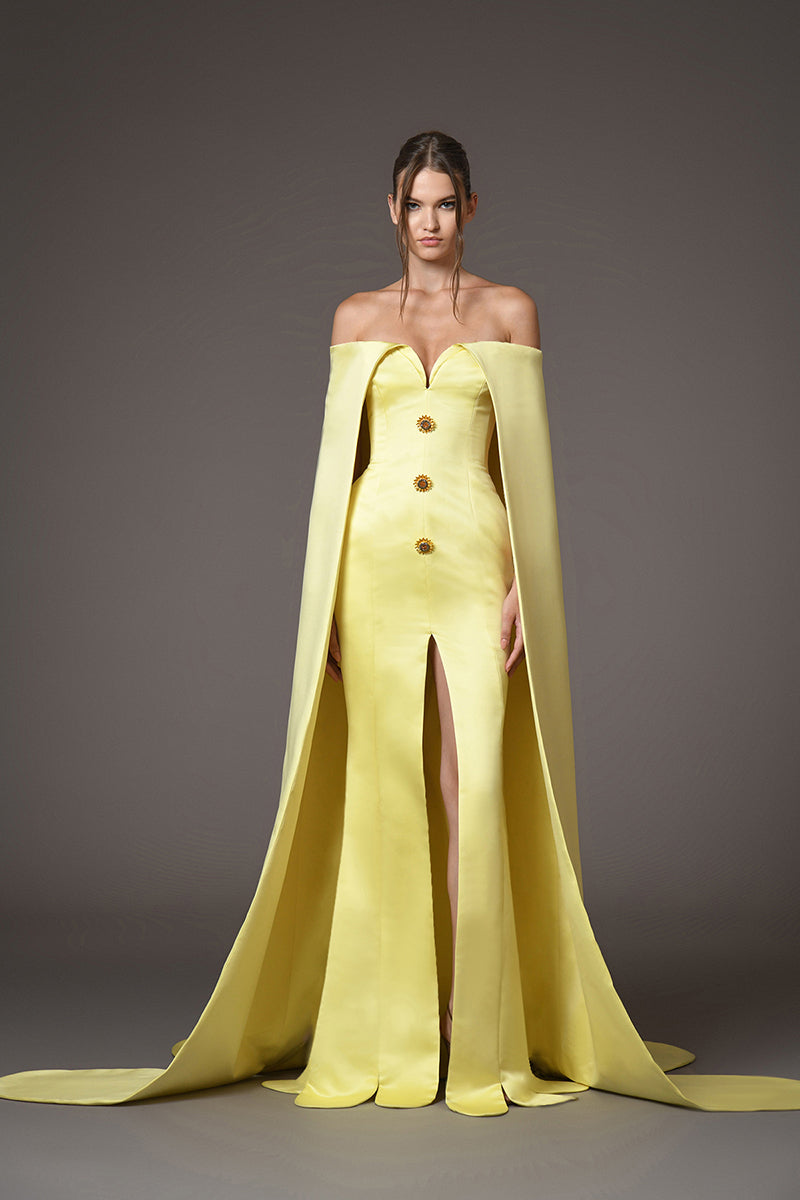 A corseted yellow gown with a cape and sunflower crystal buttons detail