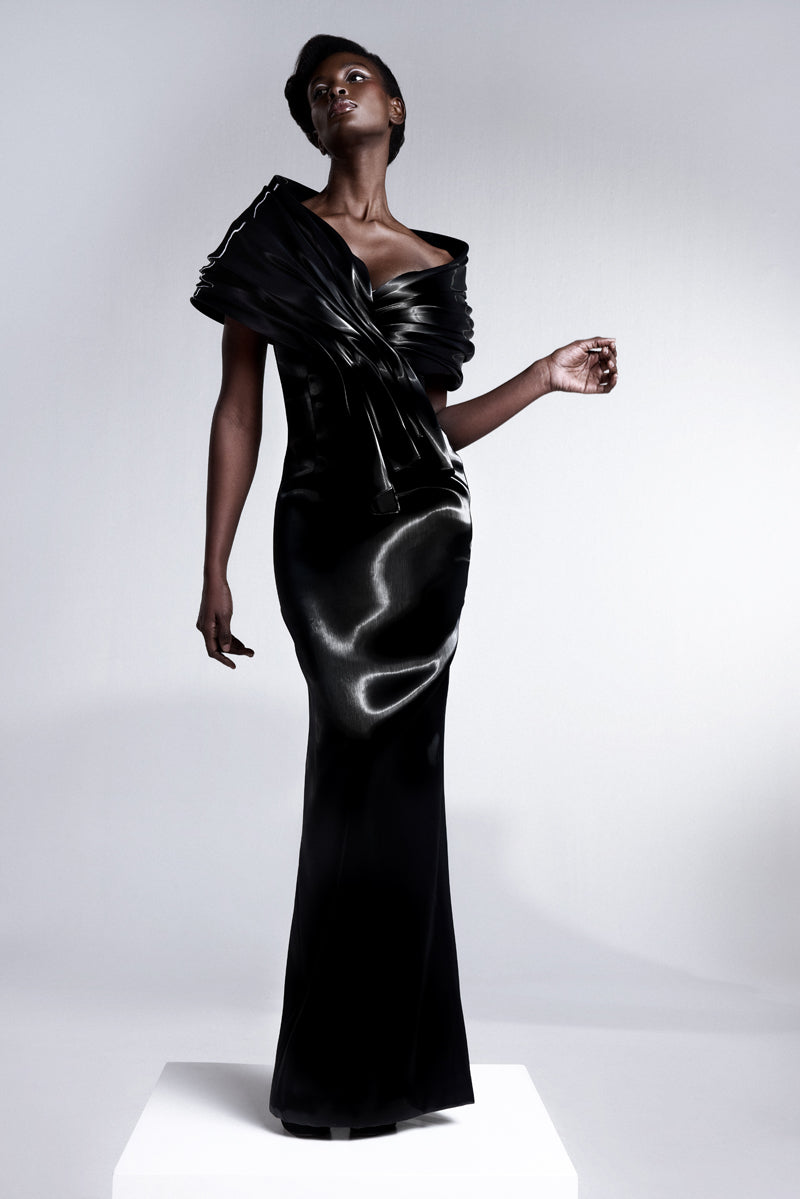 An off-shoulder liquid gazar dress with sculptural draping on the bust