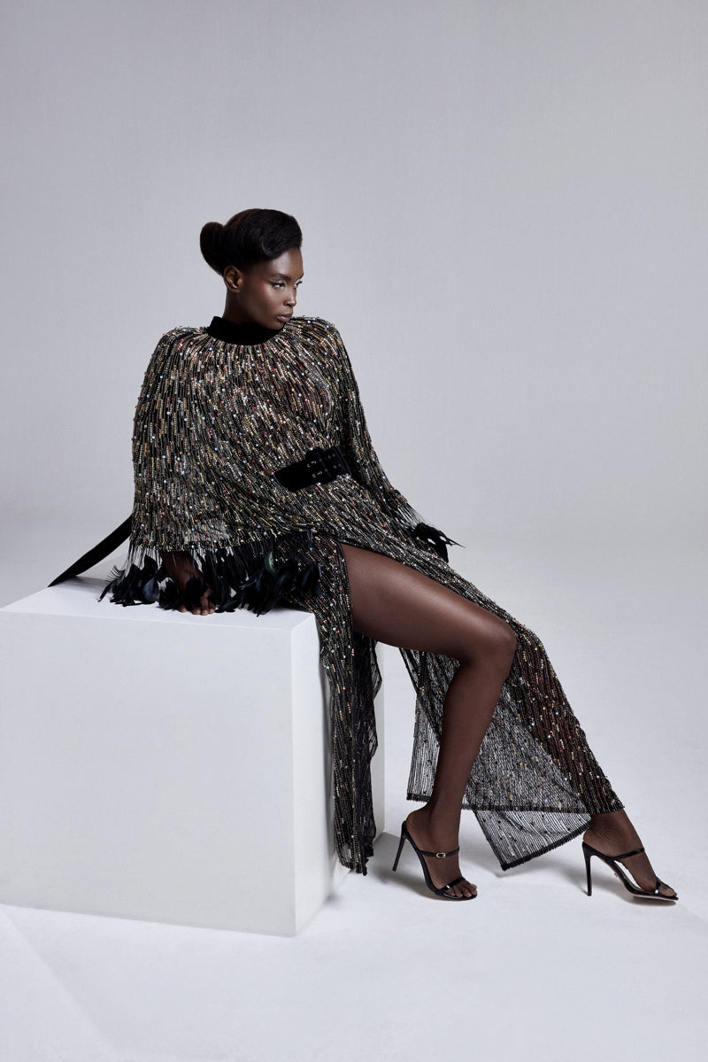 An embroidered kaftan gown with high neck and wide sleeves with feathers