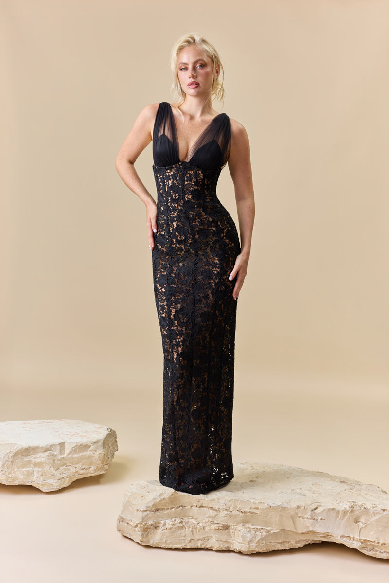 A fitted floor-length guipure dress with a deep V-neckline featuring tulle drapes at the bust.