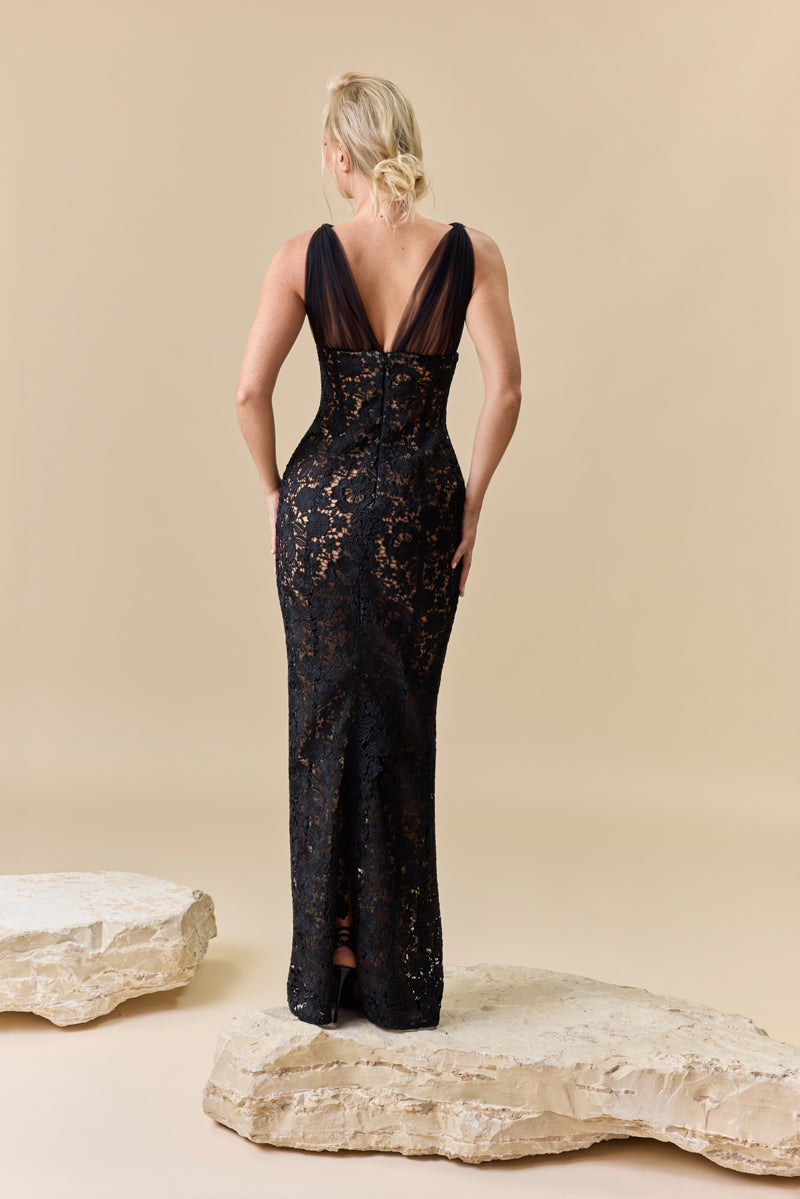A fitted floor-length guipure dress with a deep V-neckline featuring tulle drapes at the bust.