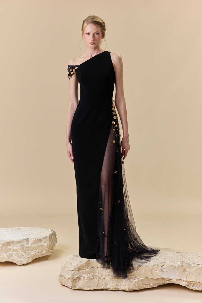 A crêpe one-shoulder fitted gown with a tulle side panel with metallic flowers and crystal beadings along the waist.