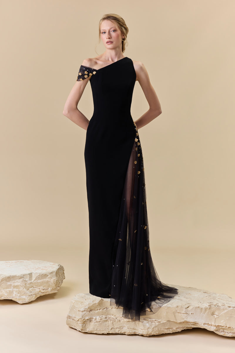 A crêpe one-shoulder fitted gown with a tulle side panel with metallic flowers and crystal beadings along the waist.