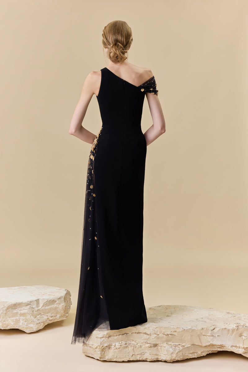 A crêpe one-shoulder fitted gown with a tulle side panel with metallic flowers and crystal beadings along the waist.