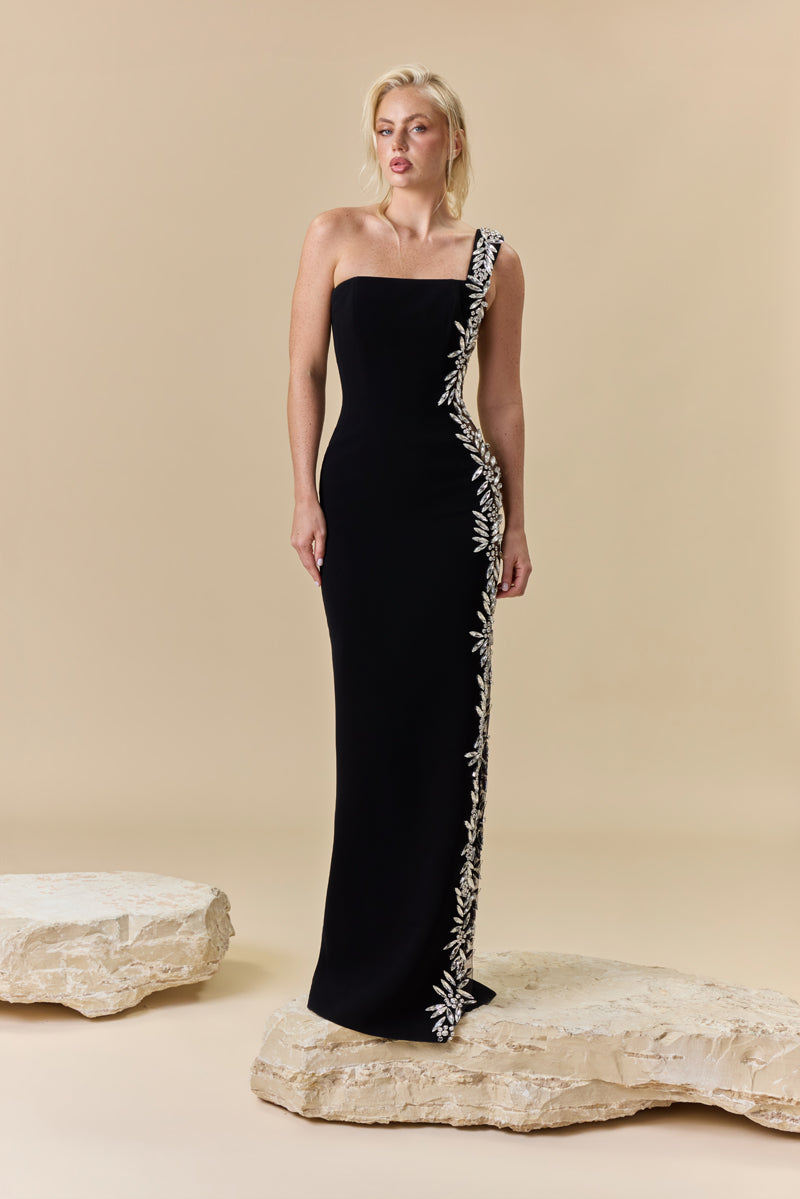 A crêpe fitted off-shoulder dress with a sheer side panel and crystal detailing on one side.