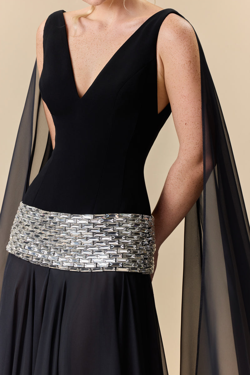 A deep V-neck dress with a crêpe fitted bodice, chiffon skirt and baguette stones beading at the hips.