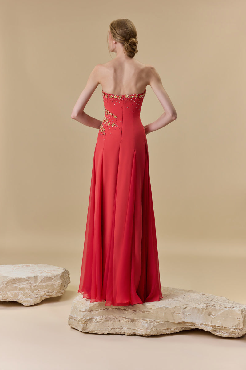 A strapless crêpe dress with A-line chiffon godet panels , embellished with metallic flowers and crystals.