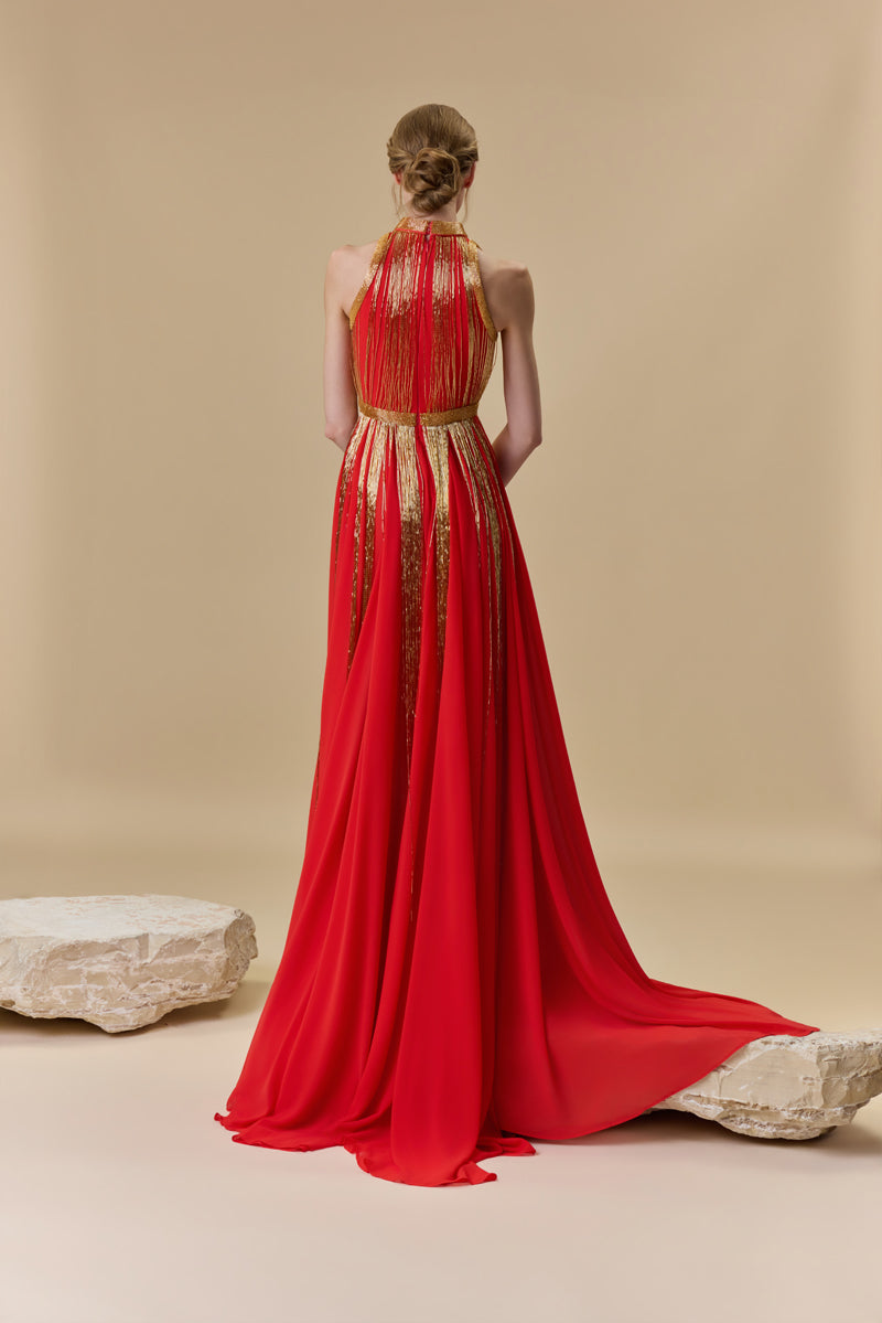 A halter neck dress featuring a crepe bodice and an A-line chiffon skirt with beaded fringes on it.