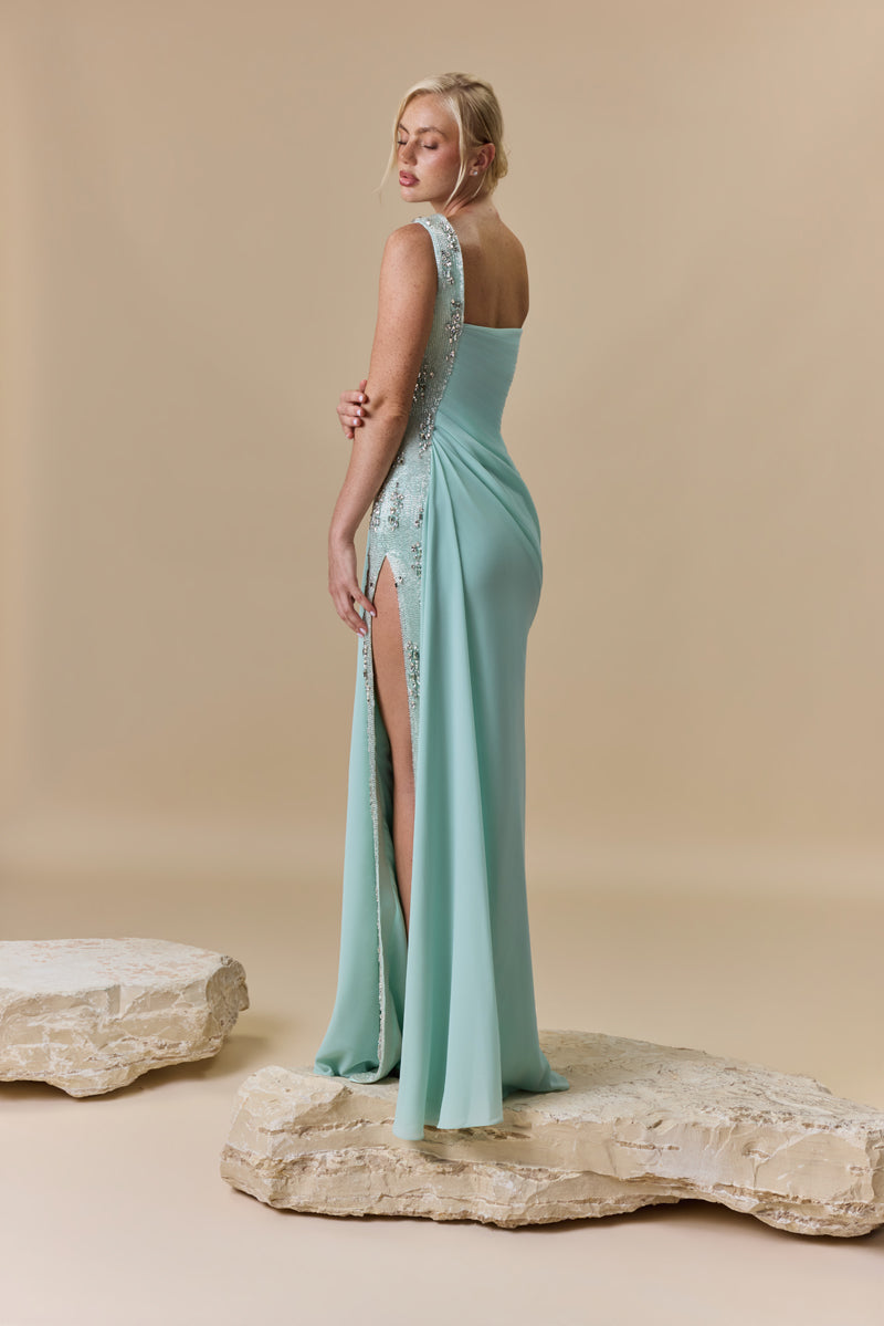 An asymmetrical one shoulder georgette dress featuring horizontal draping across the bodice and a crystal-embellished side panel.