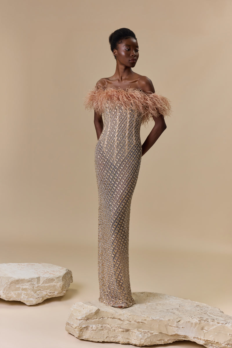 A strapless fitted dress fully beaded with crystals and finished with an off-shoulder feather trimmed neckline.