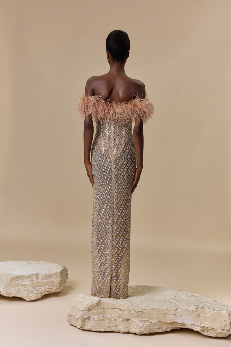 A strapless fitted dress fully beaded with crystals and finished with an off-shoulder feather trimmed neckline.