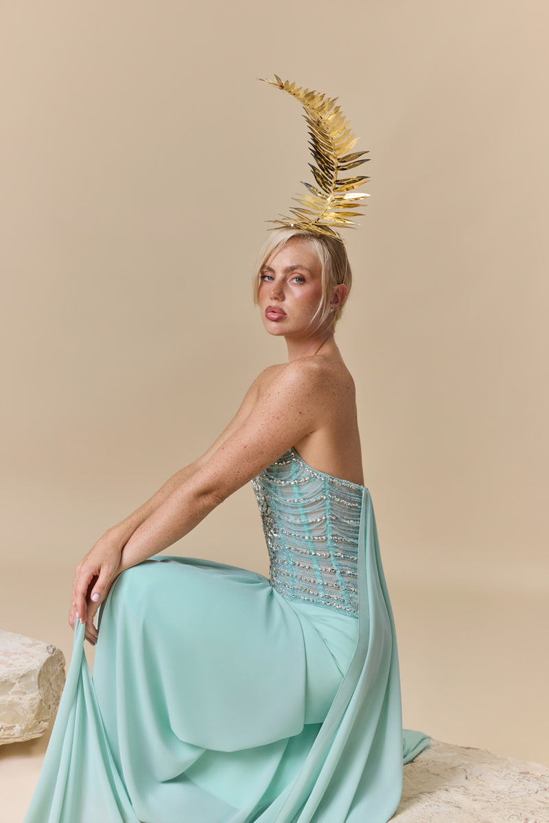 A strapless dress featuring a crystal-embellished corset bodice and a draped georgette skirt with a flowing back train.