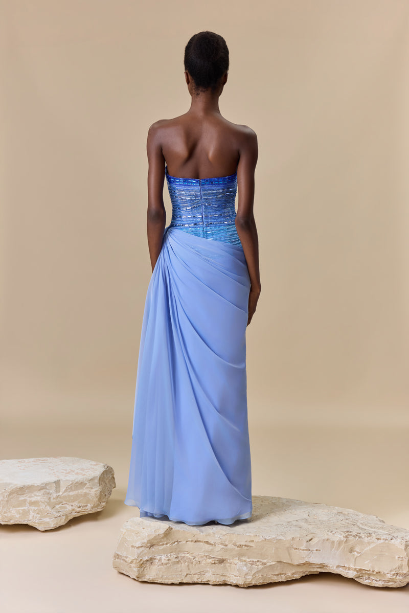 A strapless dress featuring an asymmetrical bodice with degraded crystal embroidery and a draped chiffon skirt.