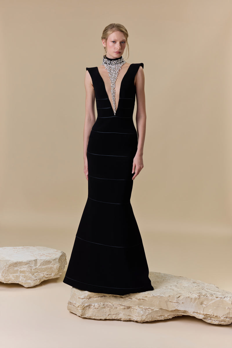 A crêpe fitted dress with a deep V neckline and horizontal radzimir detailing along the silhouette.