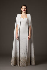 Embroidered light grey crêpe dress paired with a cape