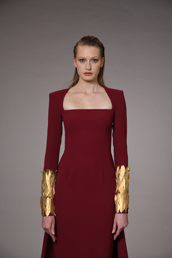 Burgundy dress with gold feathers on hem and sleeves