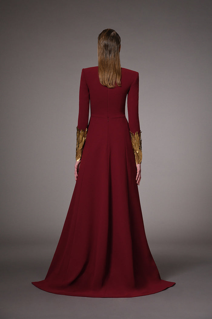 Burgundy dress with gold feathers on hem and sleeves