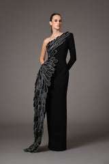 A sculpted gown in black crepe paired with a winged cape of layered hand-crafted plumes in scuba and crystals