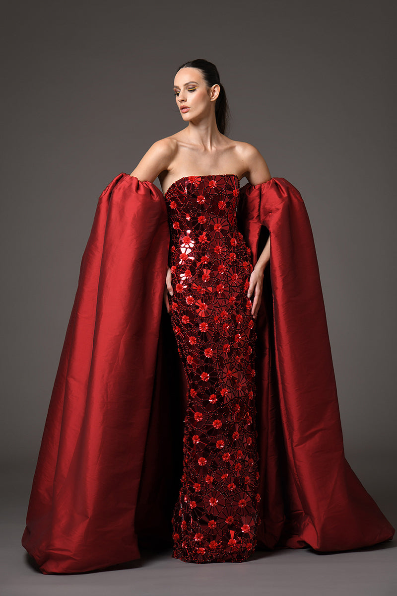 A red dress with intricate floral patterns embroidered with mirror plexiglass, with detachable taffeta sleeves/cape