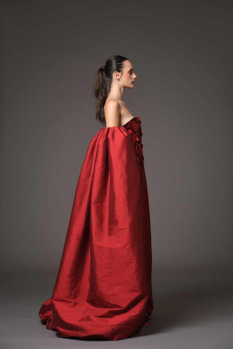 A red dress with intricate floral patterns embroidered with mirror plexiglass, with detachable taffeta sleeves/cape side