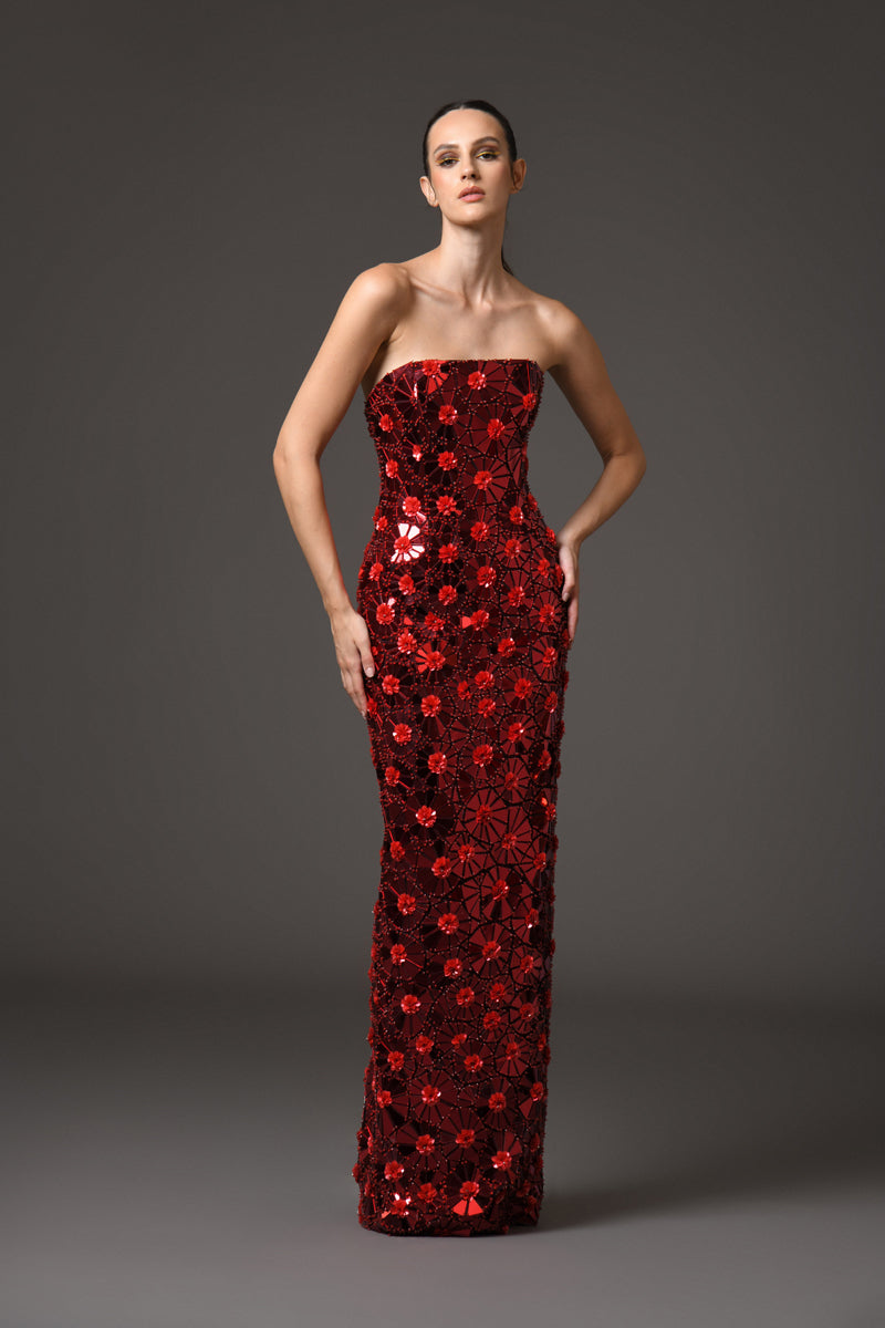 A red dress with intricate floral patterns embroidered with mirror plexiglass