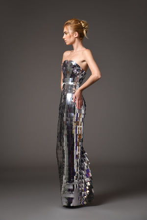A futuristic dress crafted from layers of intricately laser-cut silver mirror pvc