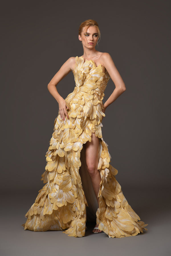 A corseted gown featuring gold hand-painted organza layered petals