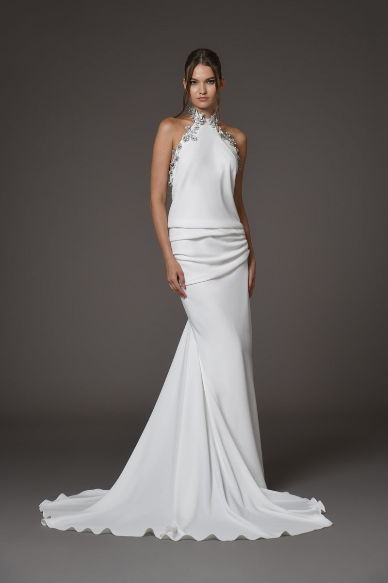 white gown with silver metal flower detailing on the halter neck with a train 