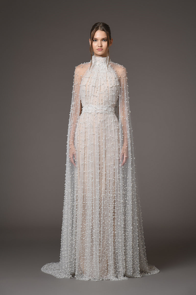 Halter neck bridal gown featuring a cape adorned with cascading pearls