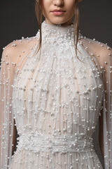 Close-up halter neck bridal gown with pearls and cape