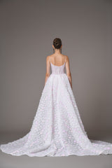 White bridal gown fully embroidered tulle with white and light pink floral bouquets featuring a dramatic overskirt back