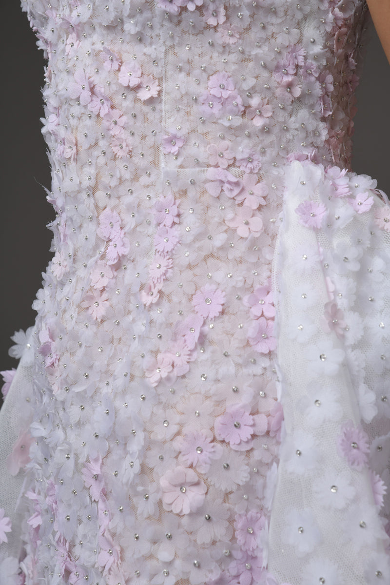 Close up bridal gown fully embroidered white tulle with white and light pink floral bouquets 