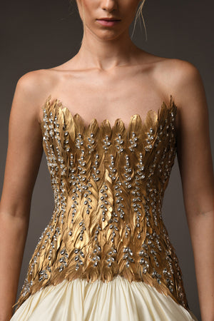 A golden feather corseted bustier, paired with a silk taffeta skirt