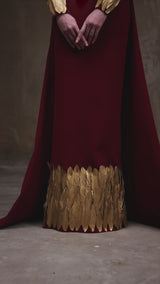 Burgundy dress with gold feathers on hem and sleeves
