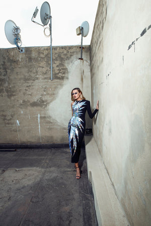 Structured asymmetrical black silk-crêpe tailored gown featuring holographic laser-cut flames emerging at the side-waist and soaring asymmetrically round the body
